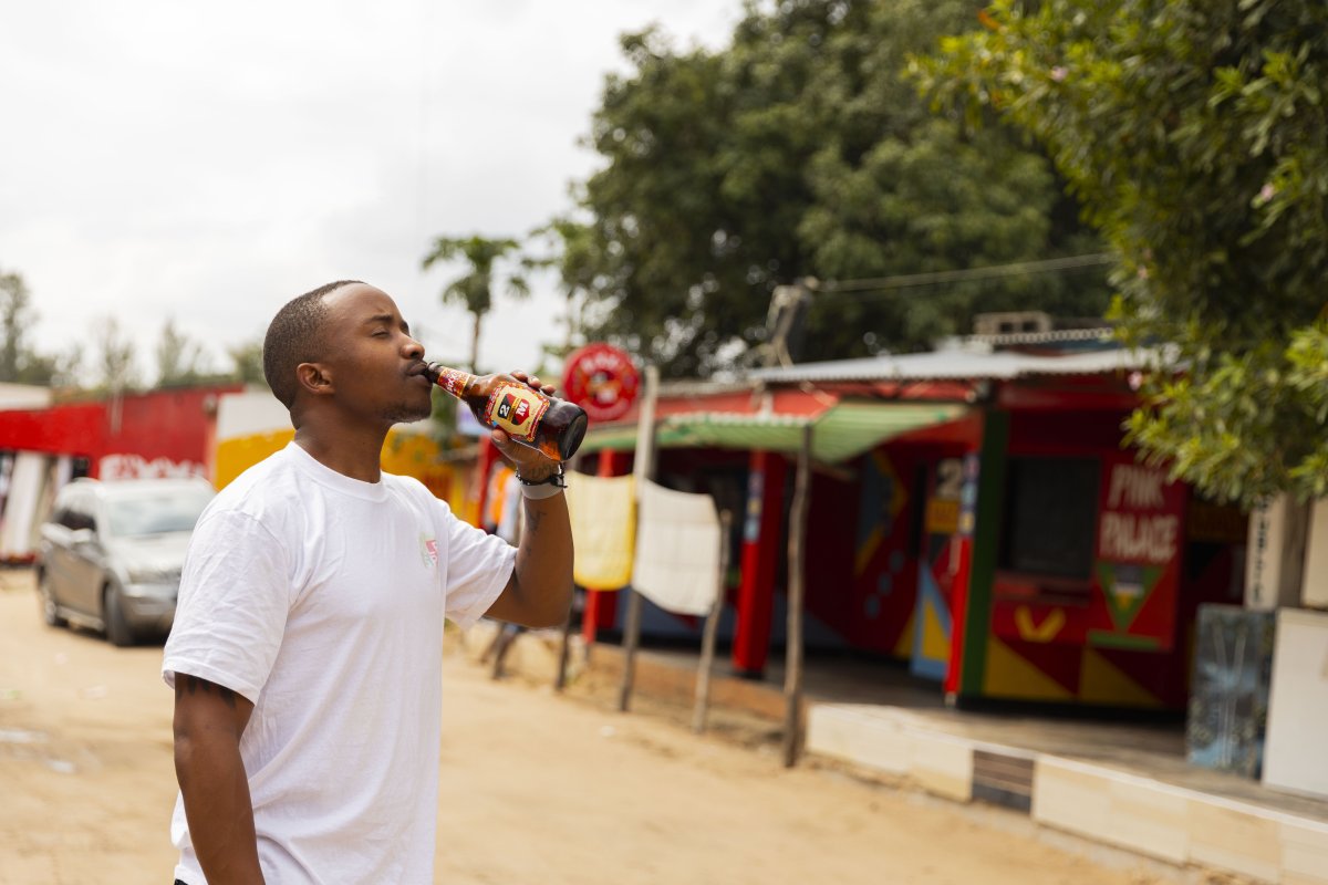 Drinking a beer in the streets of Mozambique with eyes closed.