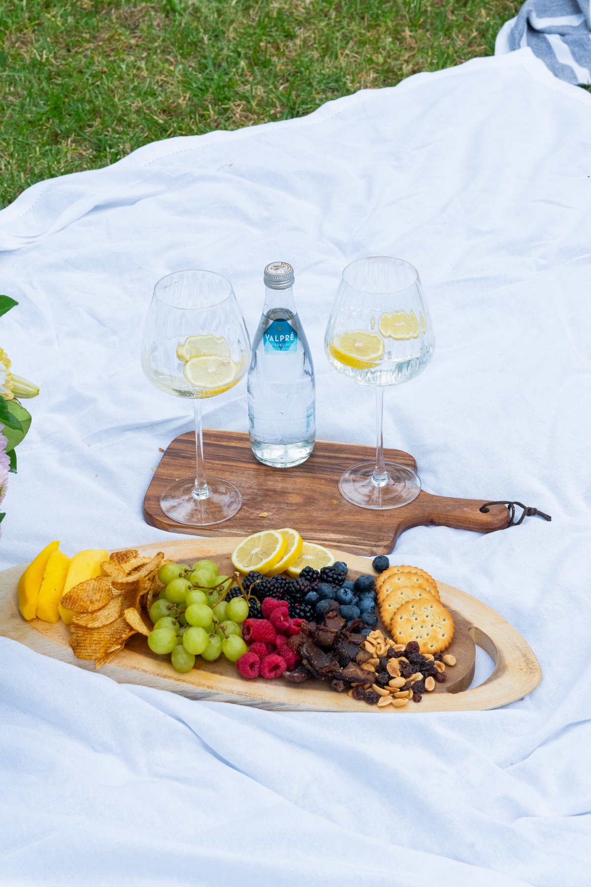 Picnic outside with snacks and water to drink on a white cloth