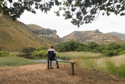Black man sitting watching the mountains