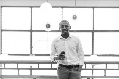 Black business man leaning over balcony at work