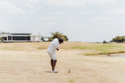 Black male golfer taking a swing at the green