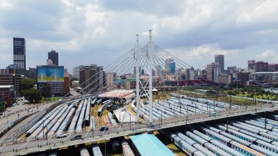 Nelson Mandela bridge from a drone with trains and the city of jozi in the background.