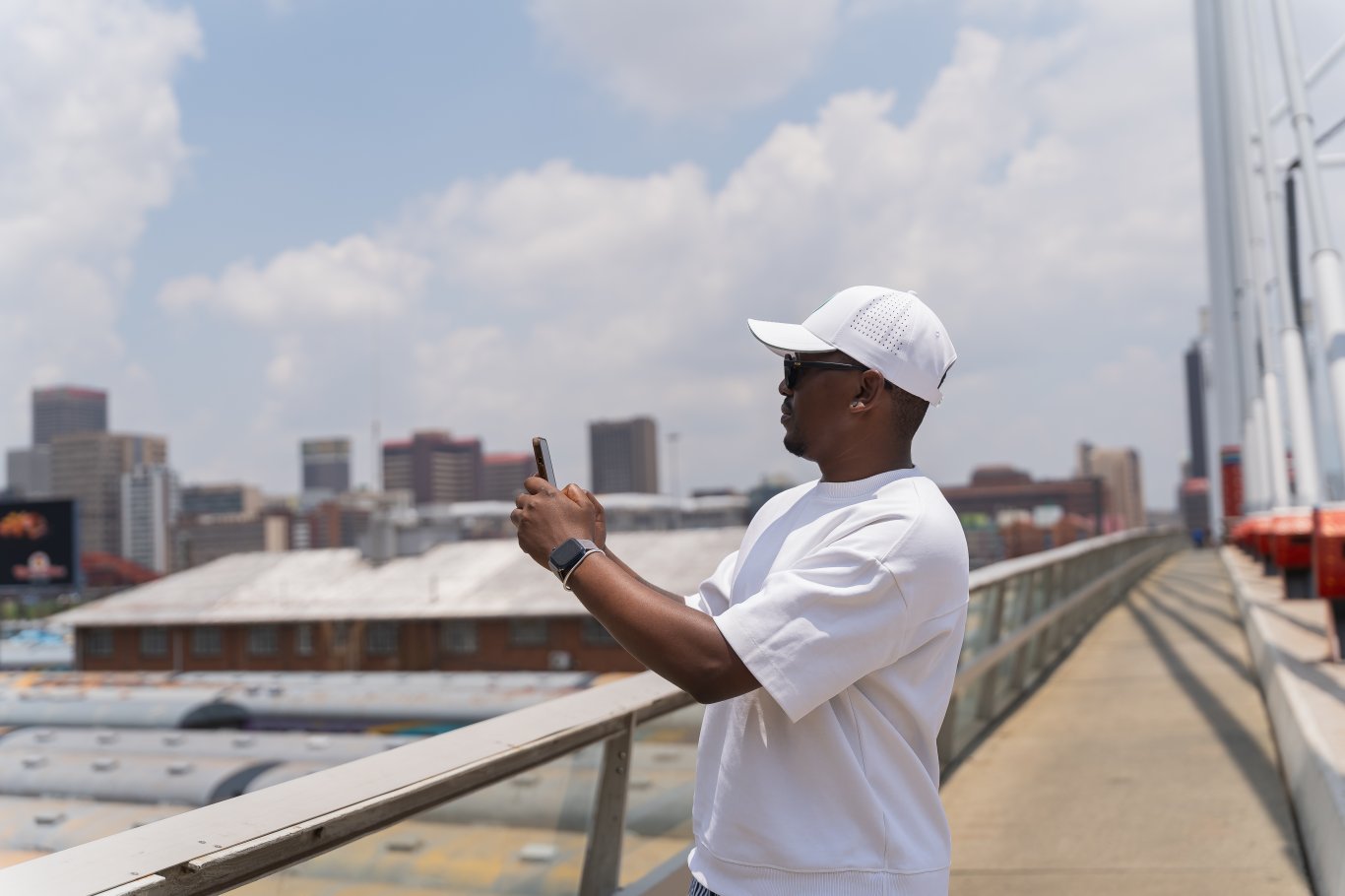 Black man using phone on nelson Mandela bridge