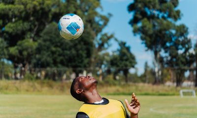 Soccer player playing with soccer ball on his head.