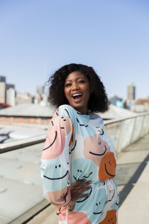 Black woman on Nelson Mandela bridge smiling with colourful clothing