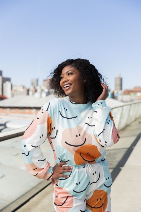 Black woman on Nelson Mandela bridge smiling with colourful clothing