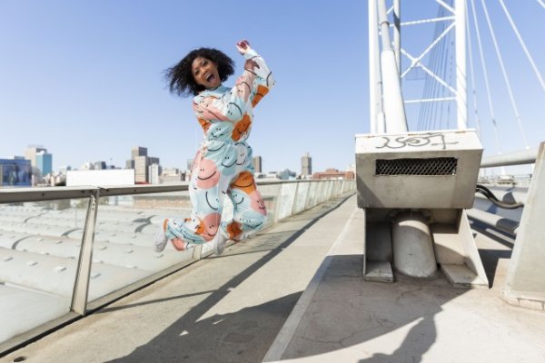 Black woman in the city jumping for joy