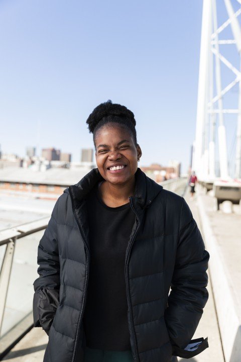 Black woman wearing all black grinning