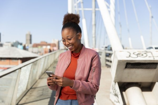 Black woman on a smartphone on Nelson Mandela bridge