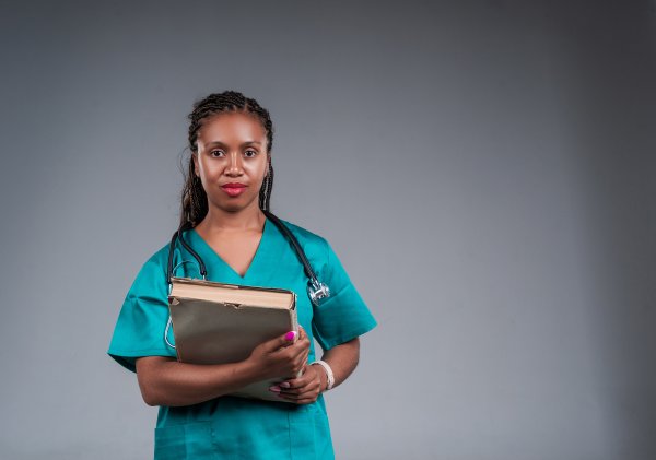African doctor with a stethoscope, holding a book in her hands
