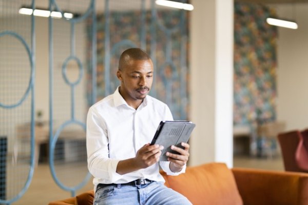 Black man looking at his tablet at work