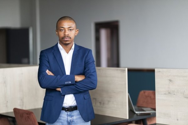 Black entrepreneur wearing a suit with folded arms