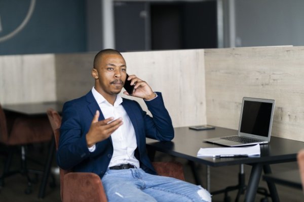 Black business man talking on his phone and wearing a suit