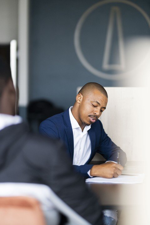 Black business man wearing a suit and talking to his client at work