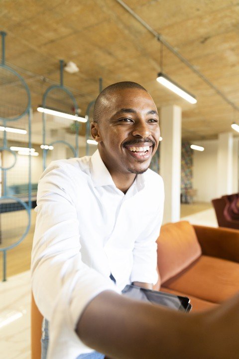 Black business man approaching to shake hands with a client at work while smiling