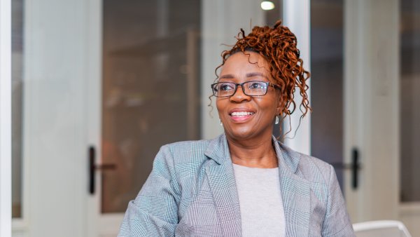 Black woman smiling wearing glasses at the office, CEO.