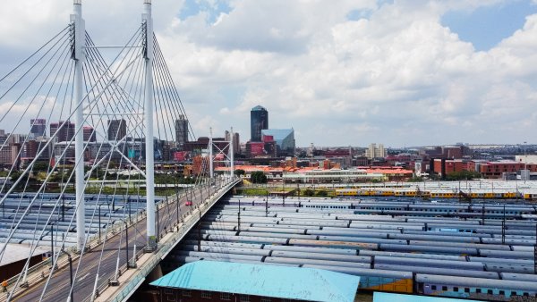 City of Johannesburg with Nelson Mandela bridge in the foreground and trains below the bridge.