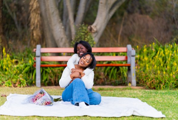 Happy mother and daughter hugging and smiling in a park outdoors.