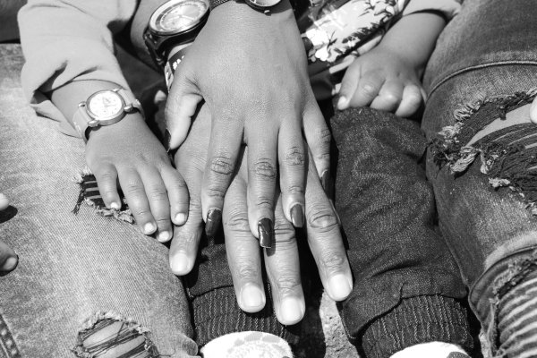 Hands of a mother and son in black and white