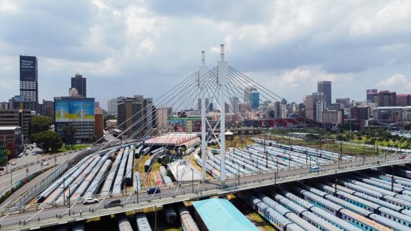 Nelson Mandela bridge from a drone with trains and the city of jozi in the background.
