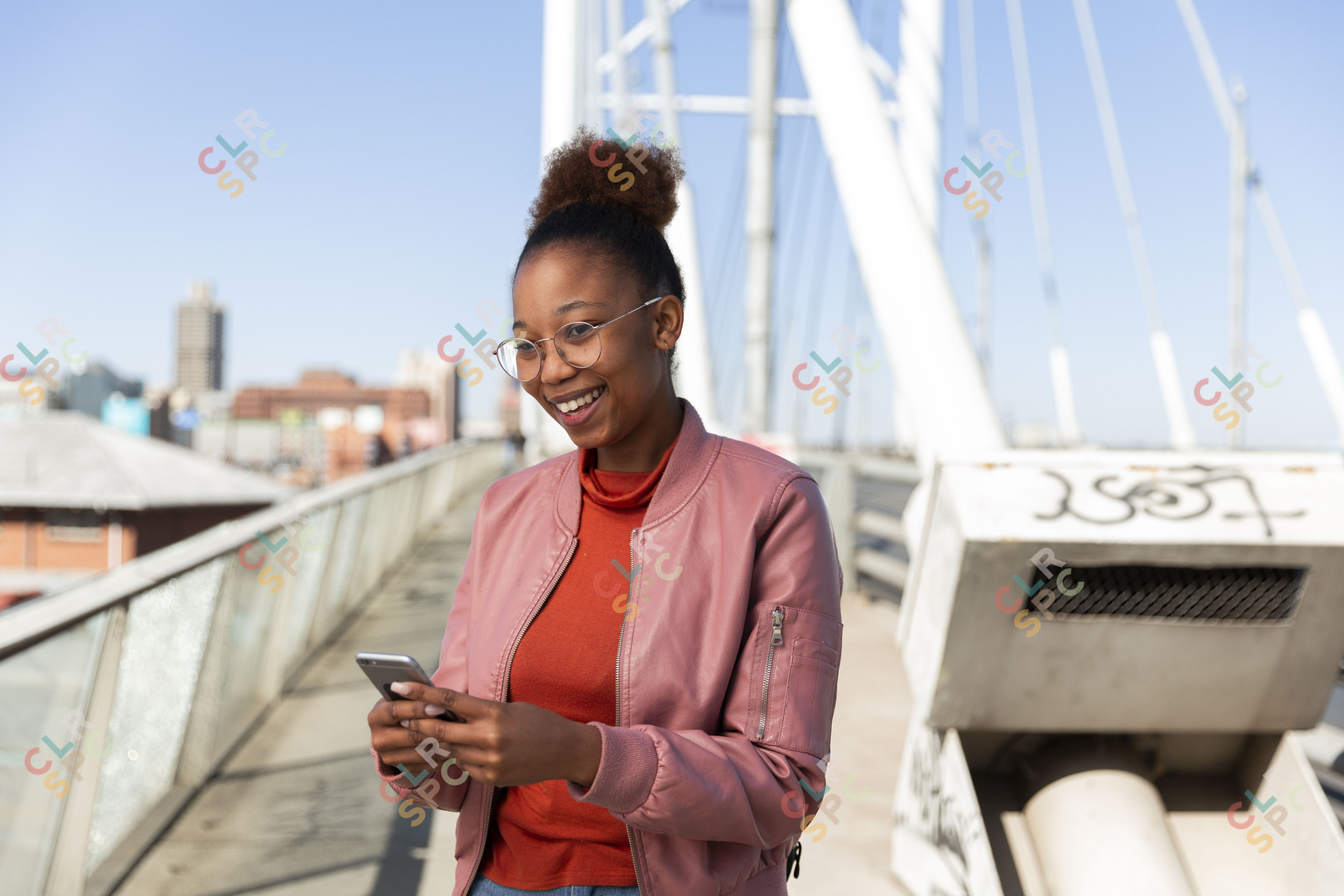 African woman smiling holding a smartphone