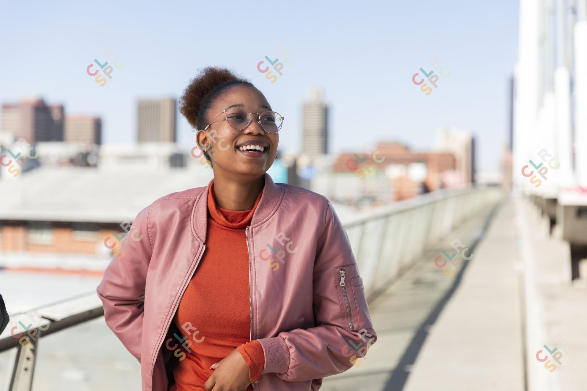 Black woman smiling wearing a pink jacket