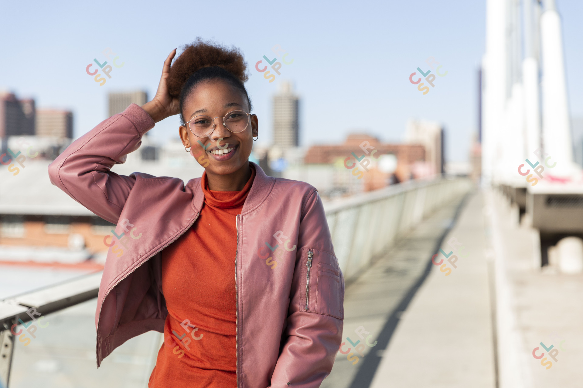 Black woman on Nelson Mandela bridge smiling with ponytail