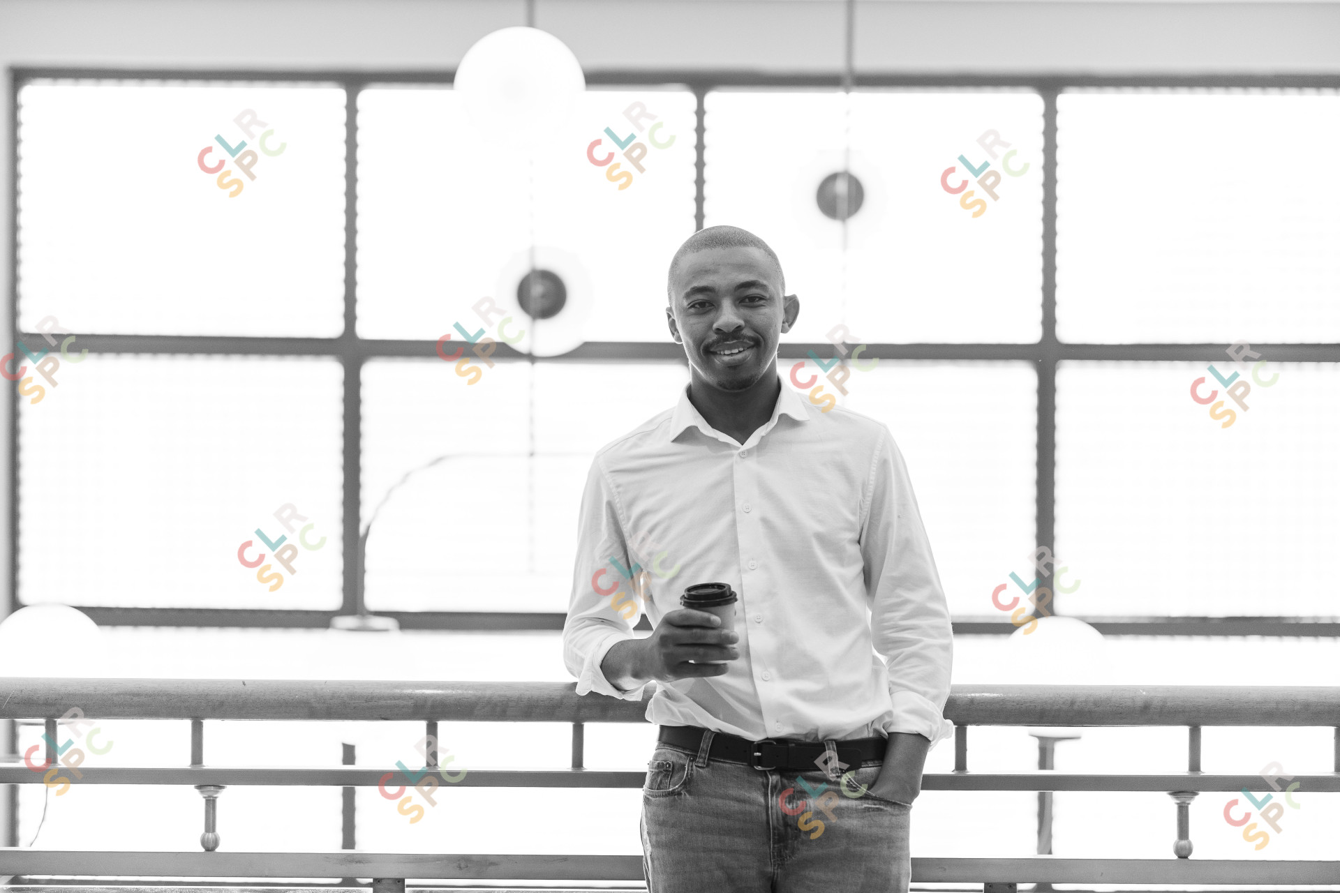 Black business man leaning over balcony at work