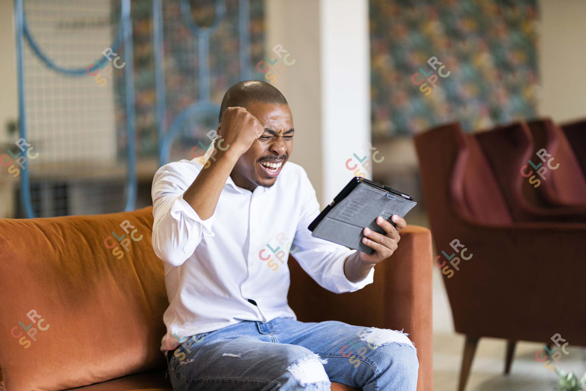 Black man celebrating and looking at ipad