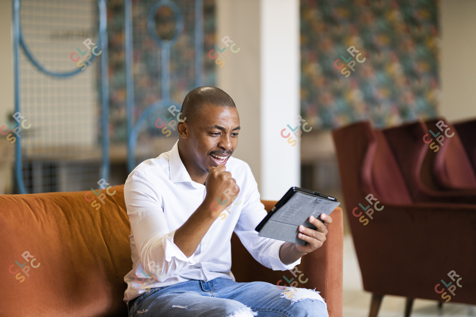 Black man celebrating and looking at ipad