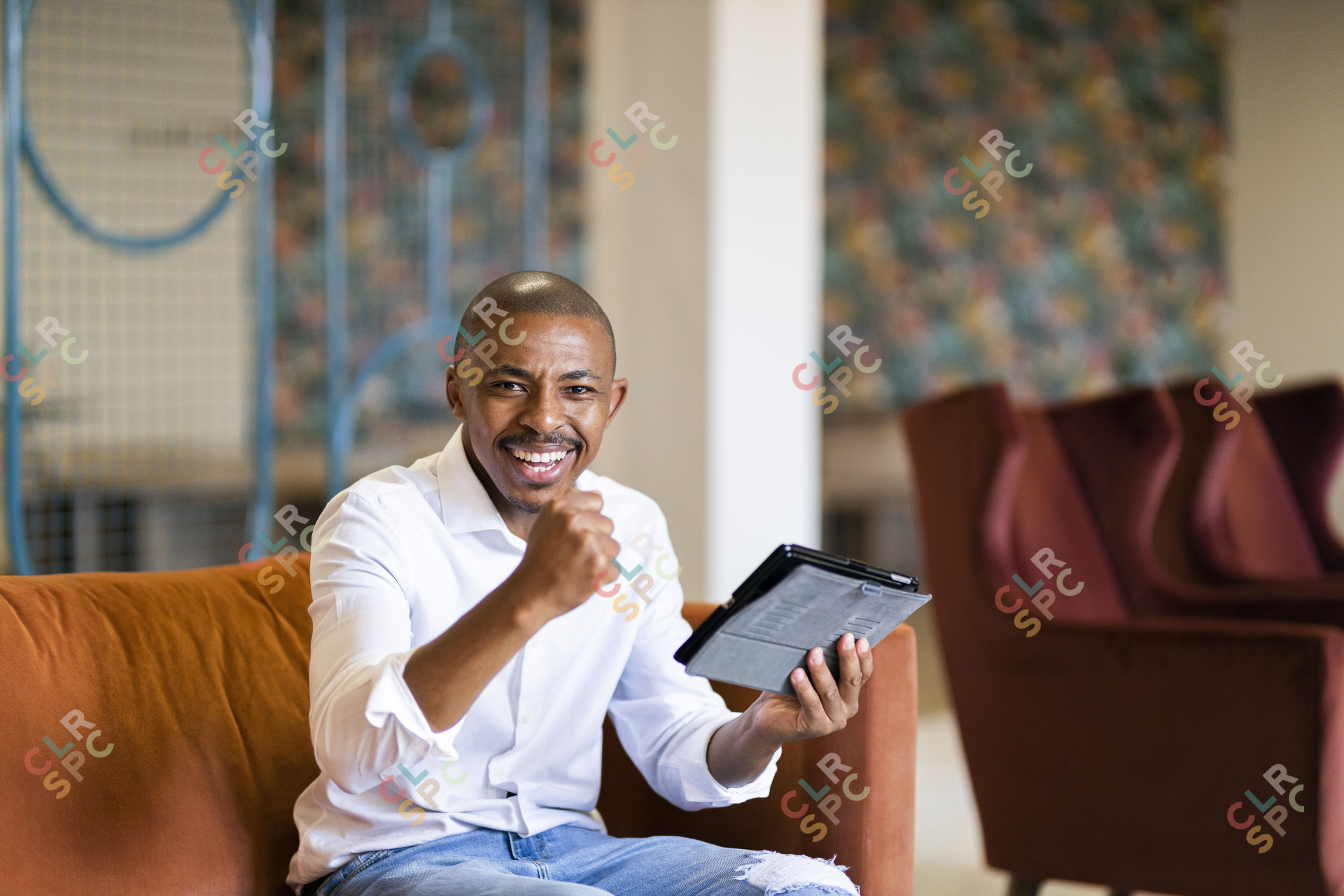 Black business man celebrating while looking at ipad
