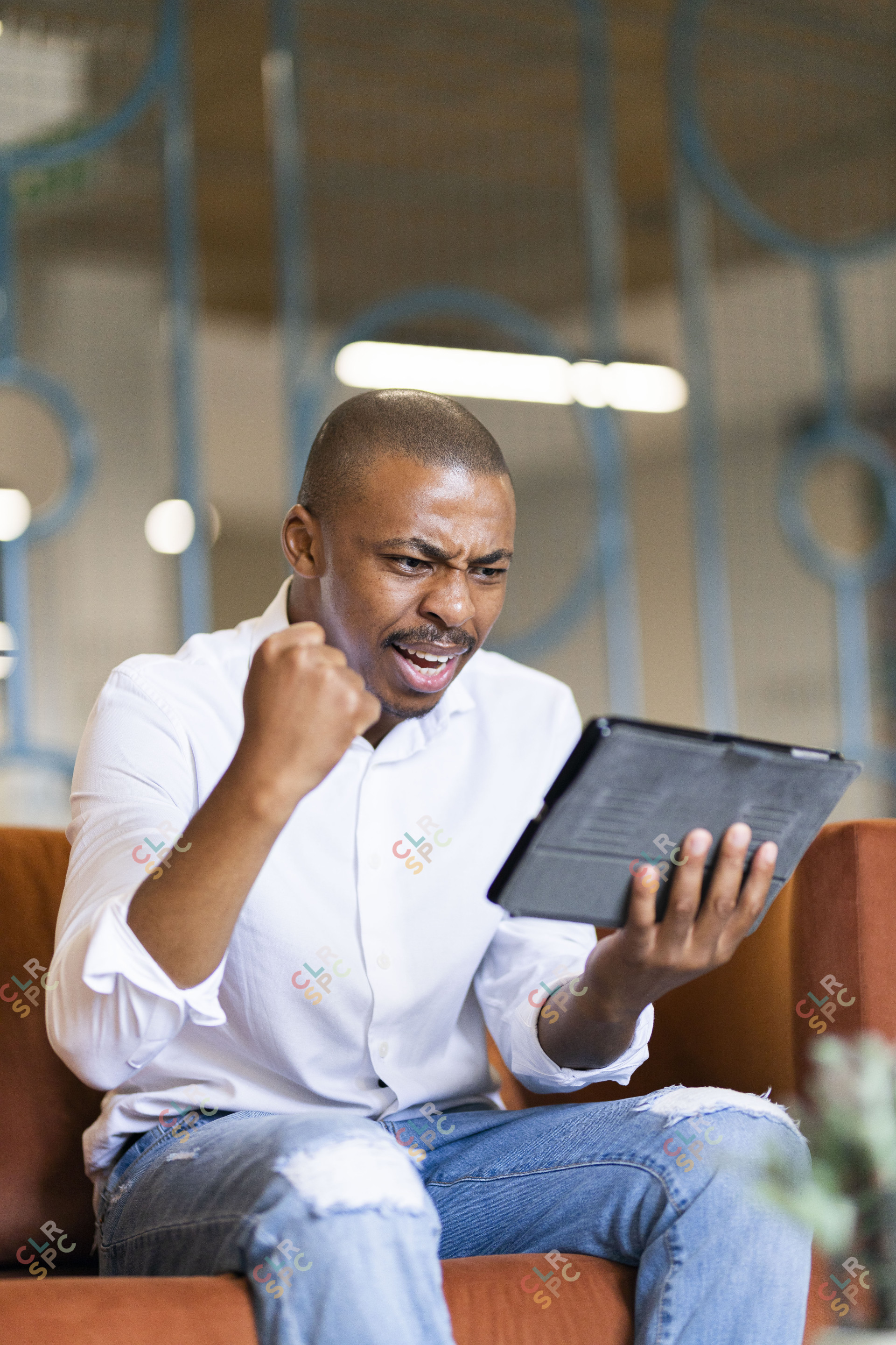 Black man celebrating looking at ipad