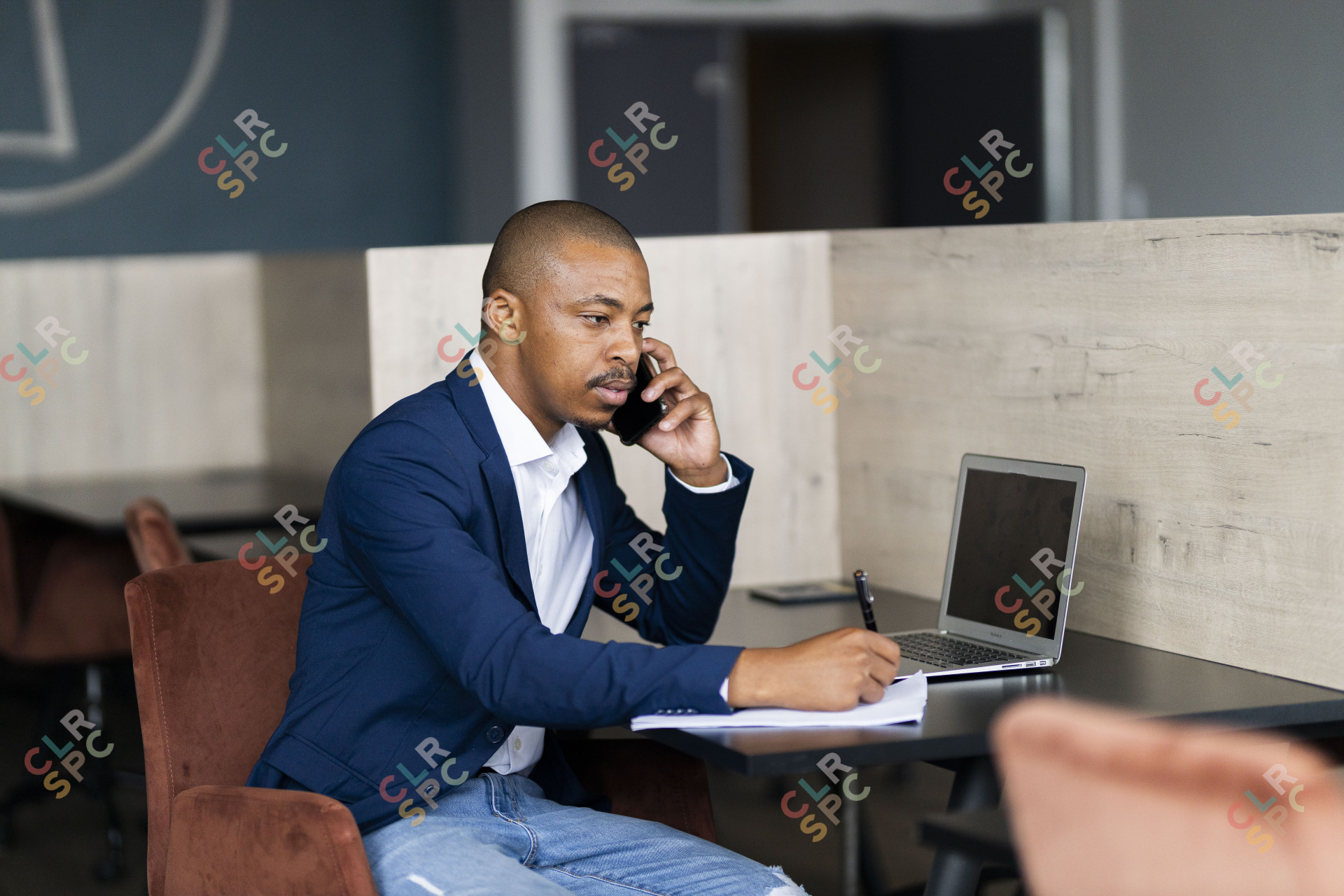 Black business man taking notes and on a phone call