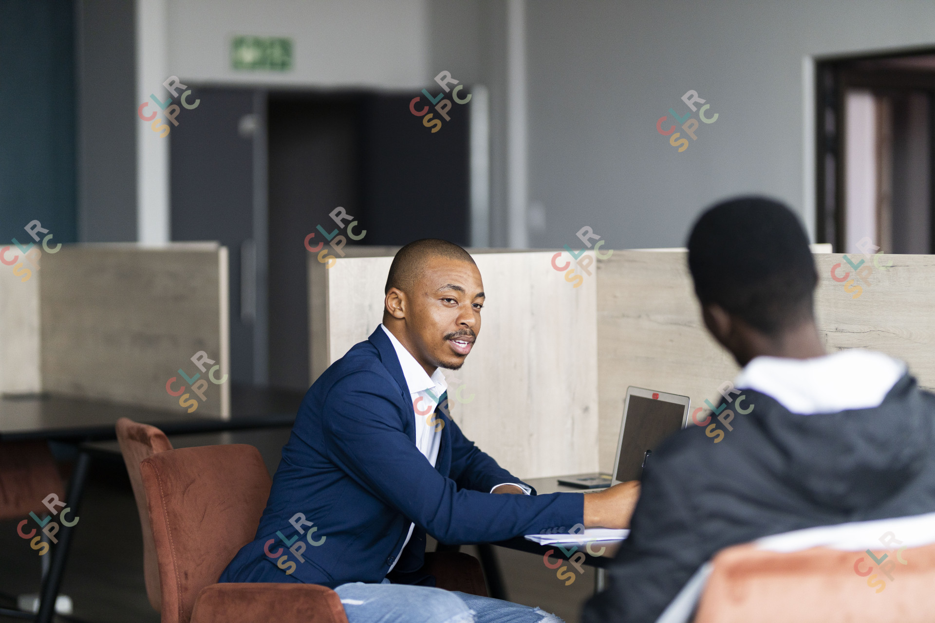 Black business man wearing a suit and talking to his client while smiling