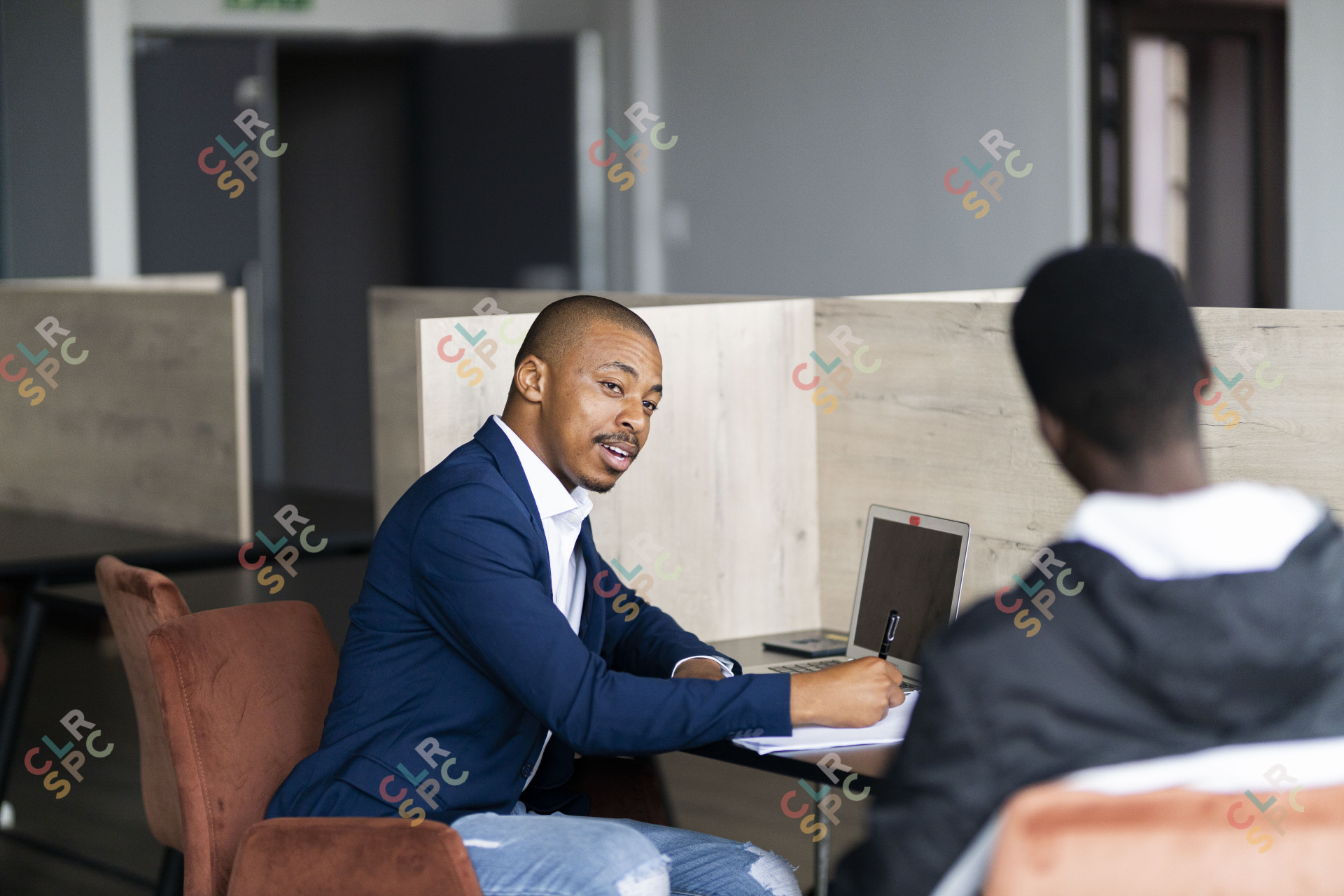 Black business man wearing a suit and talking to his client at work and taking notes