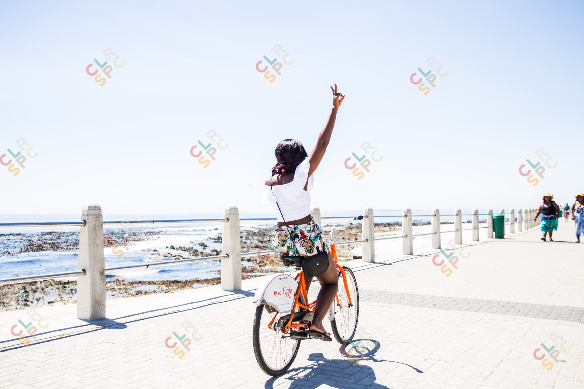 Black woman riding bicycle by the beach