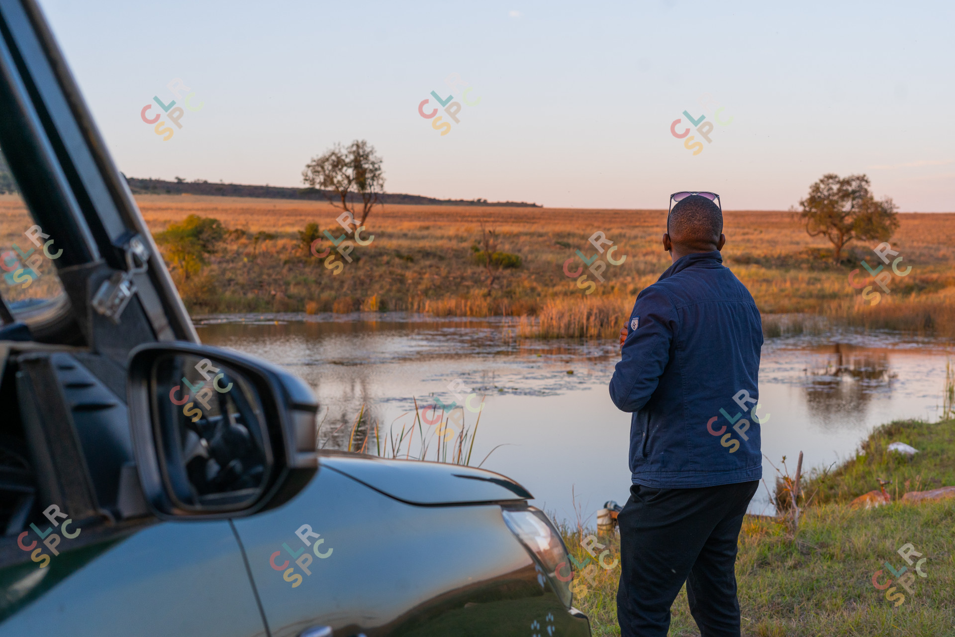 Black man at a dam near a car camping.