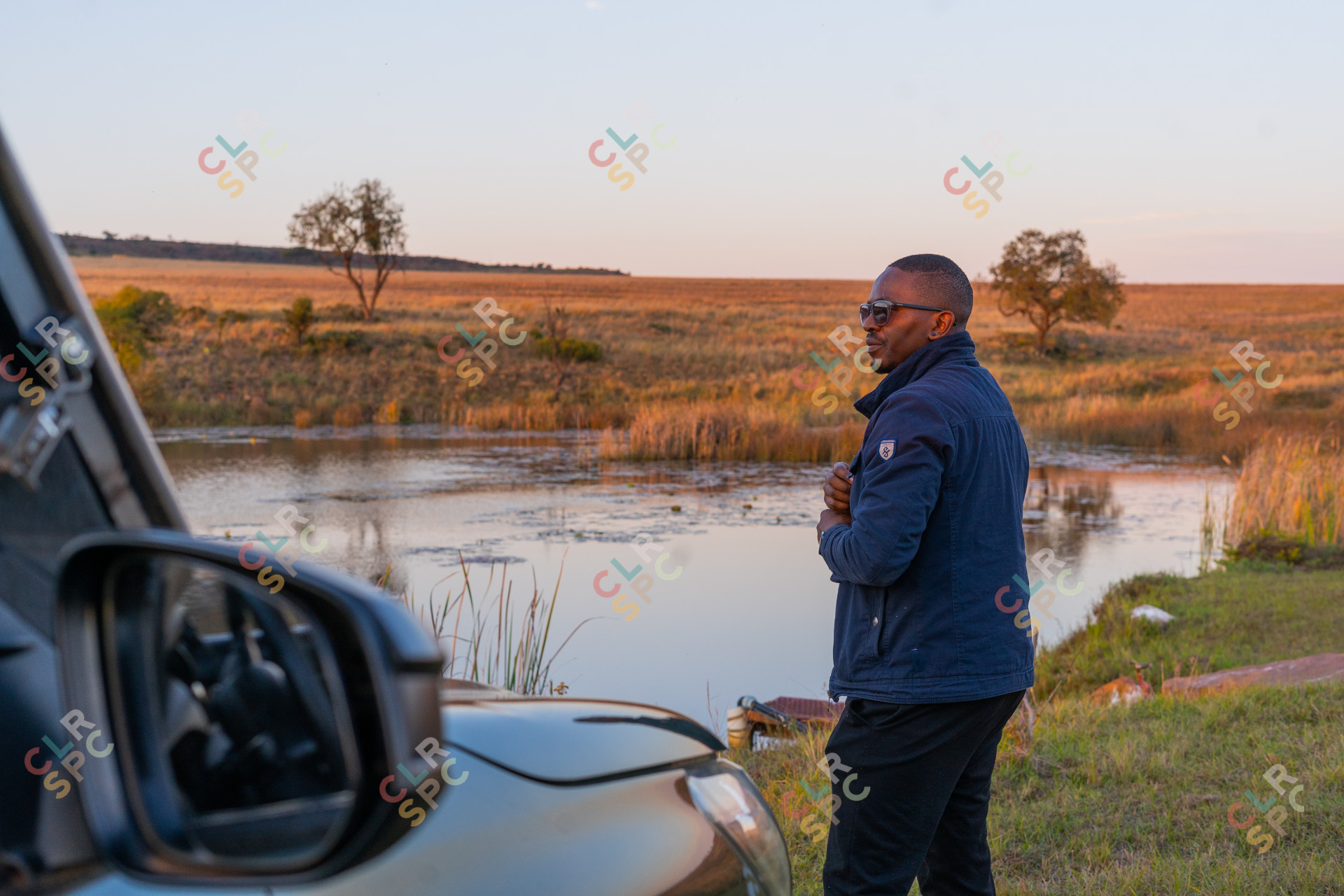 Black man overlooking a damn near a car while camping