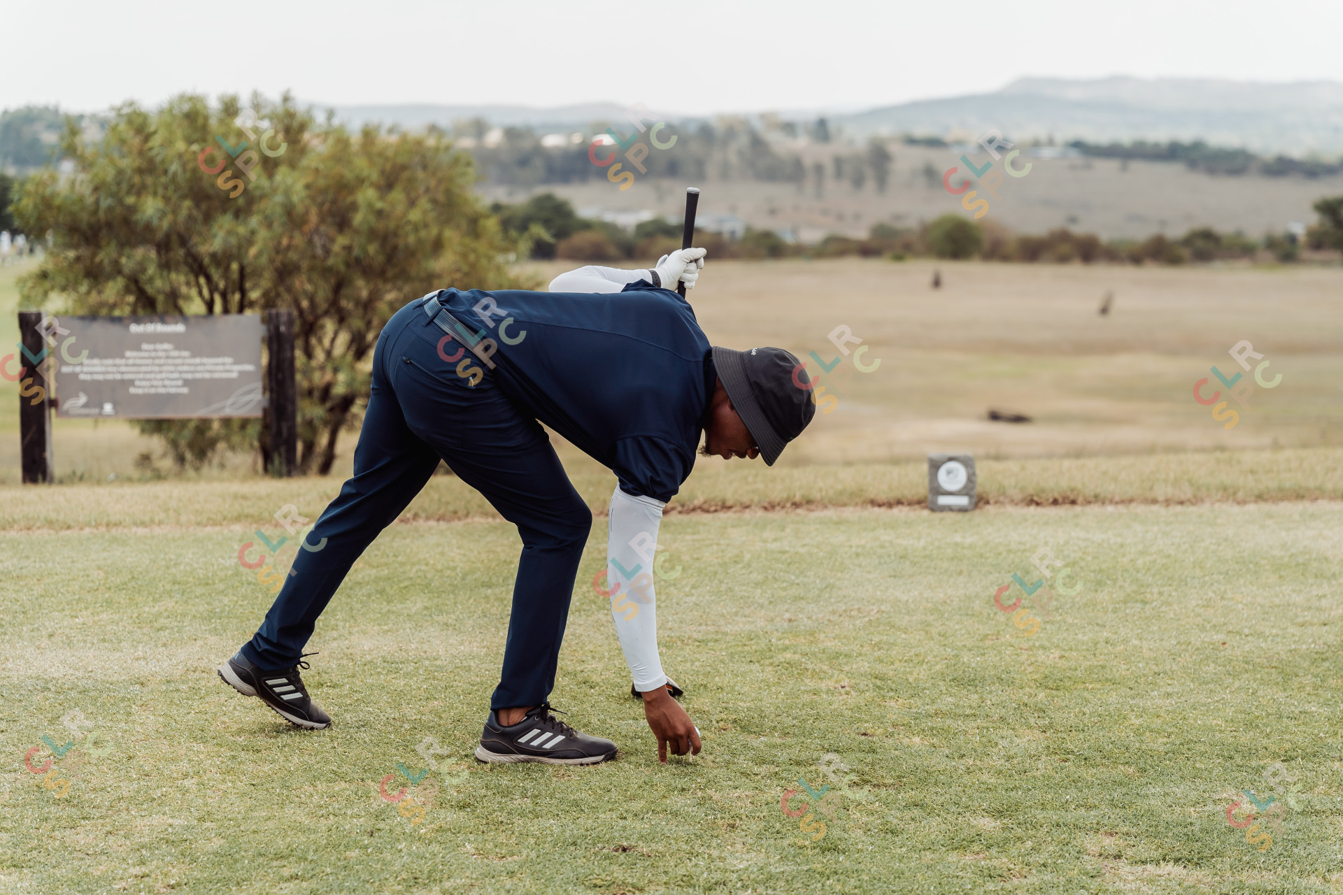 Black male golfer placing golf ball on the golf course