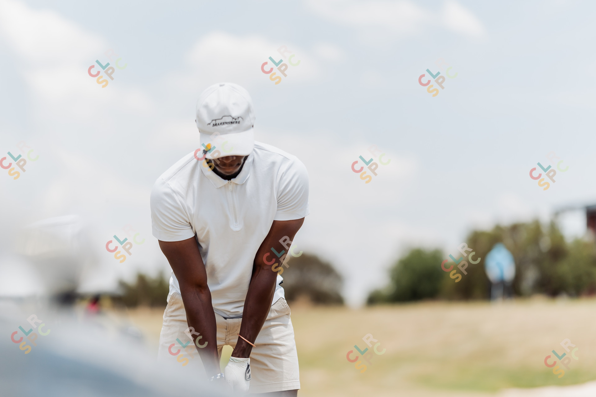 Black male golfer focusing on taking a golf shot