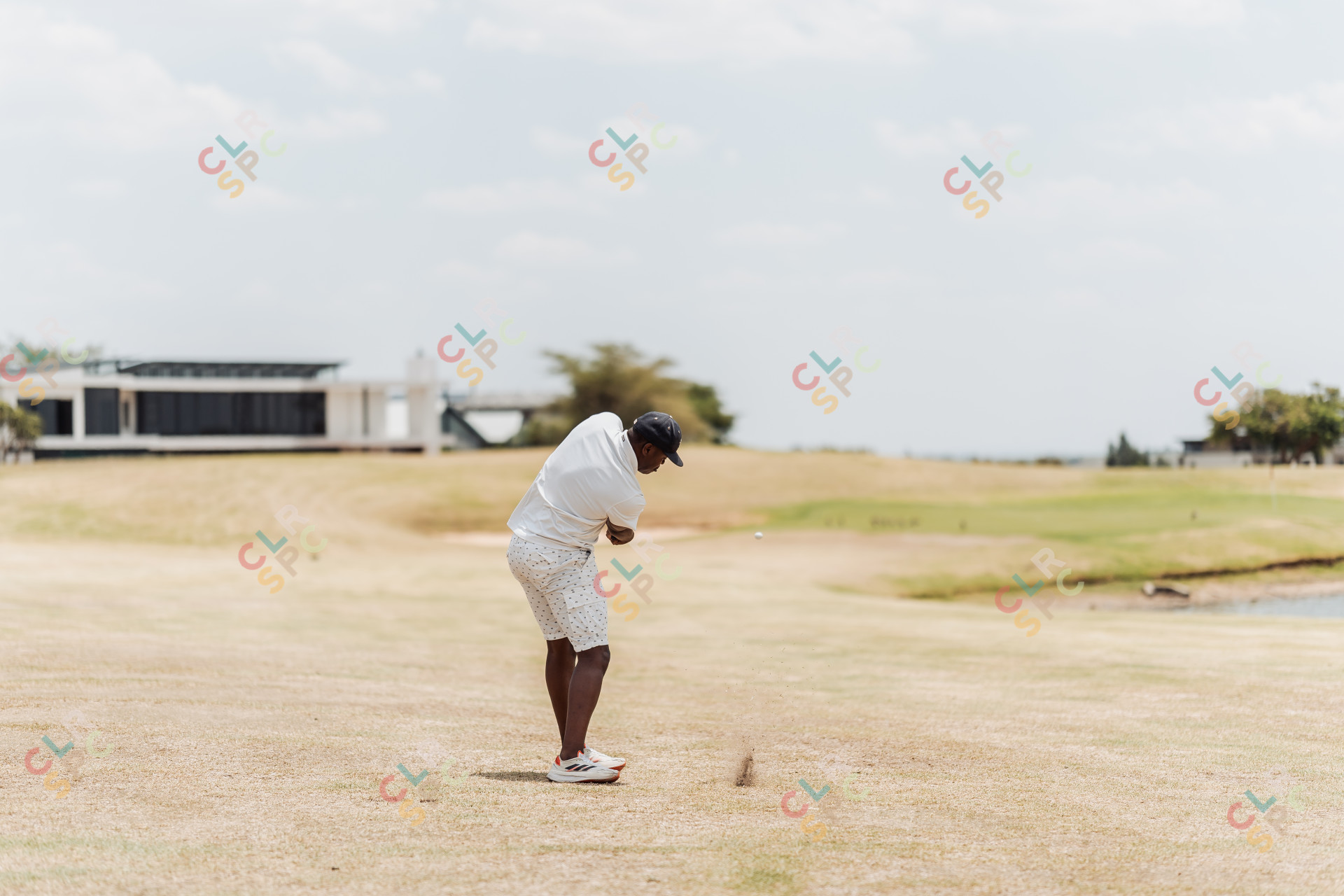 Black male golfer taking a swing at the green