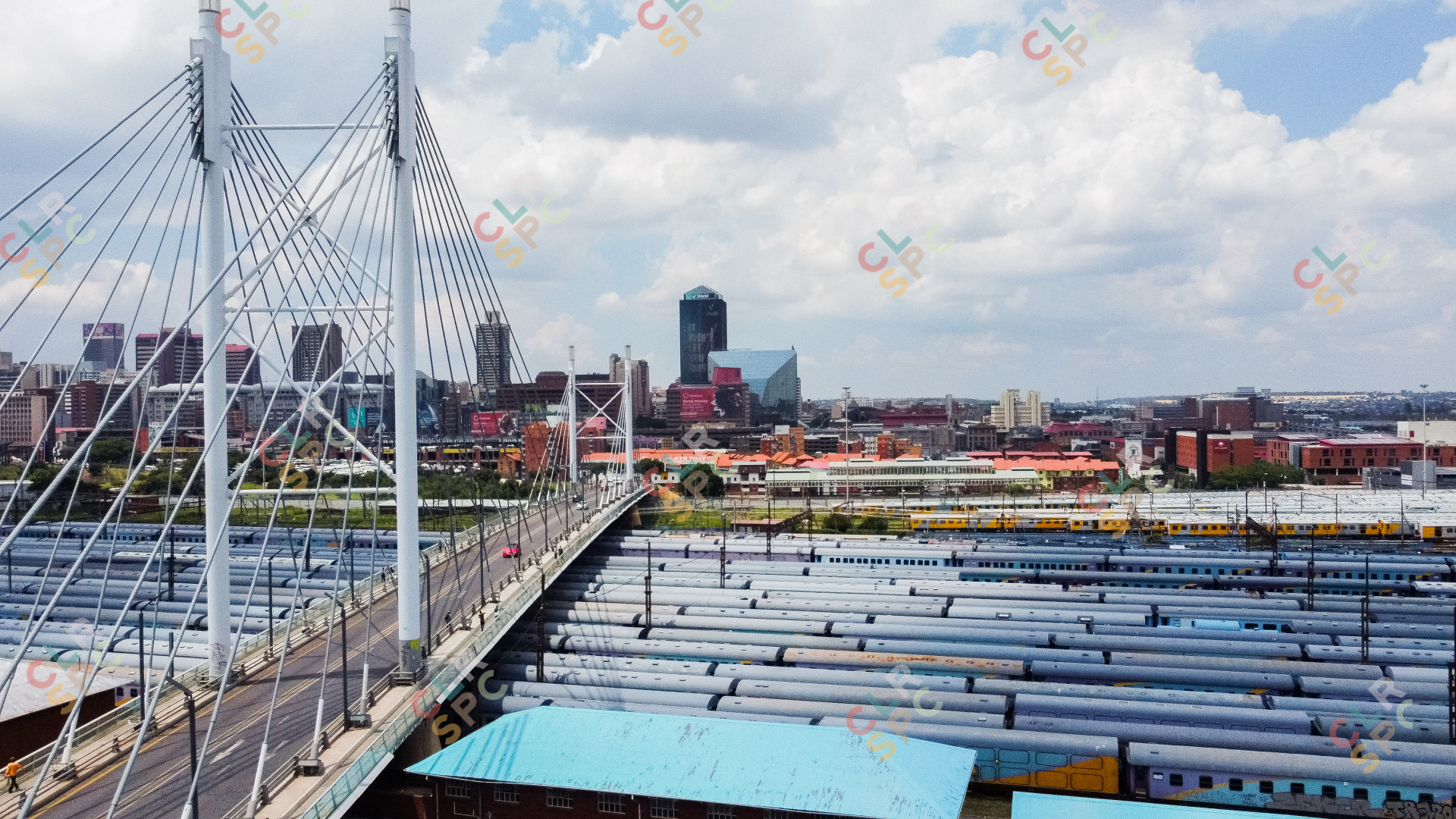 City of Johannesburg with Nelson Mandela bridge in the foreground and trains below the bridge.