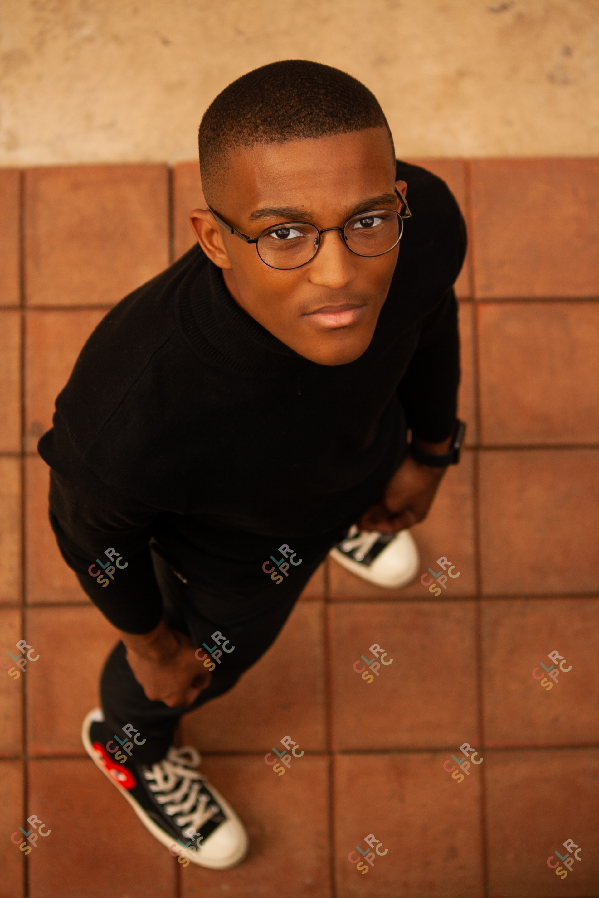Black man wearing glasses looking up