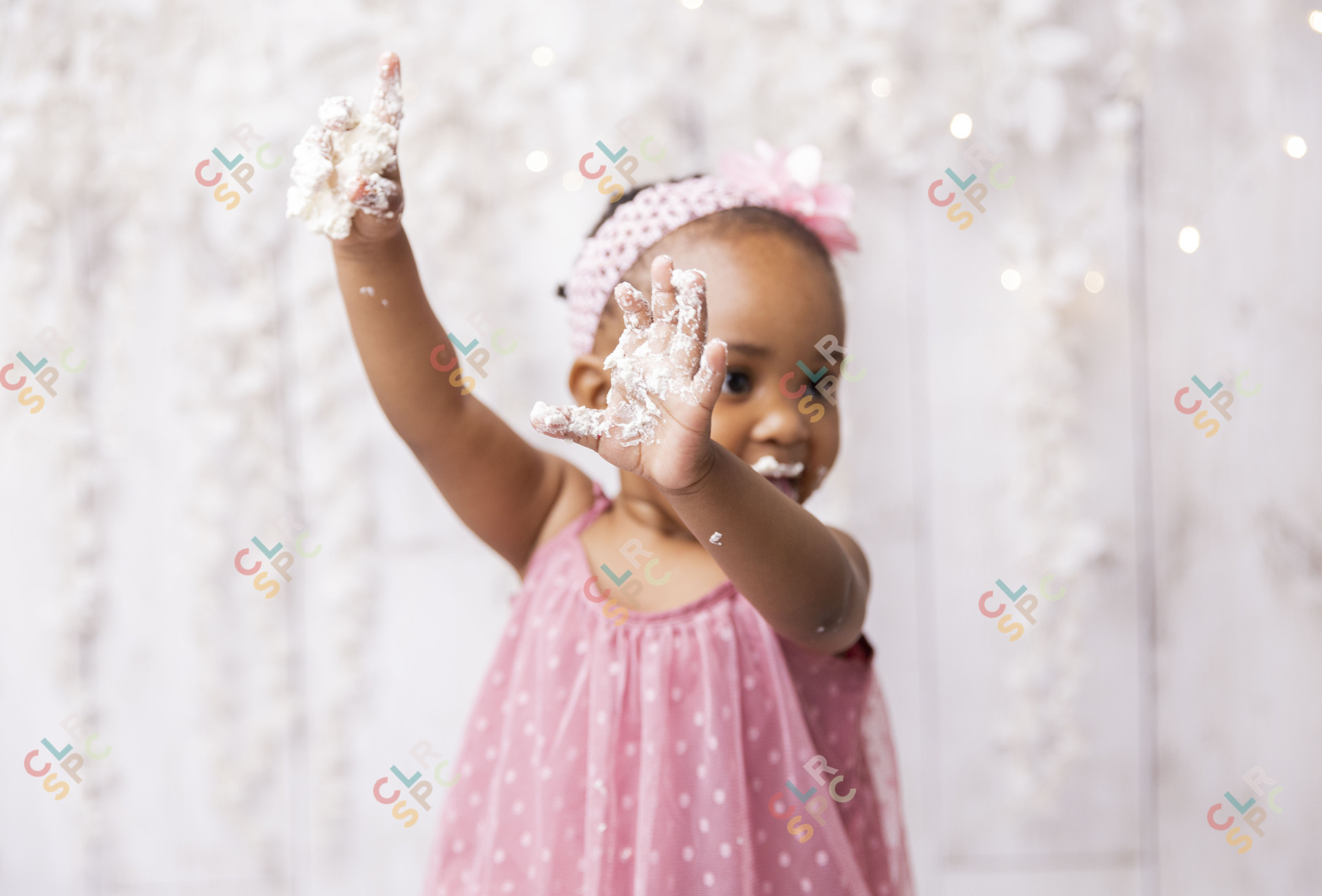 Black baby girl playing with cake