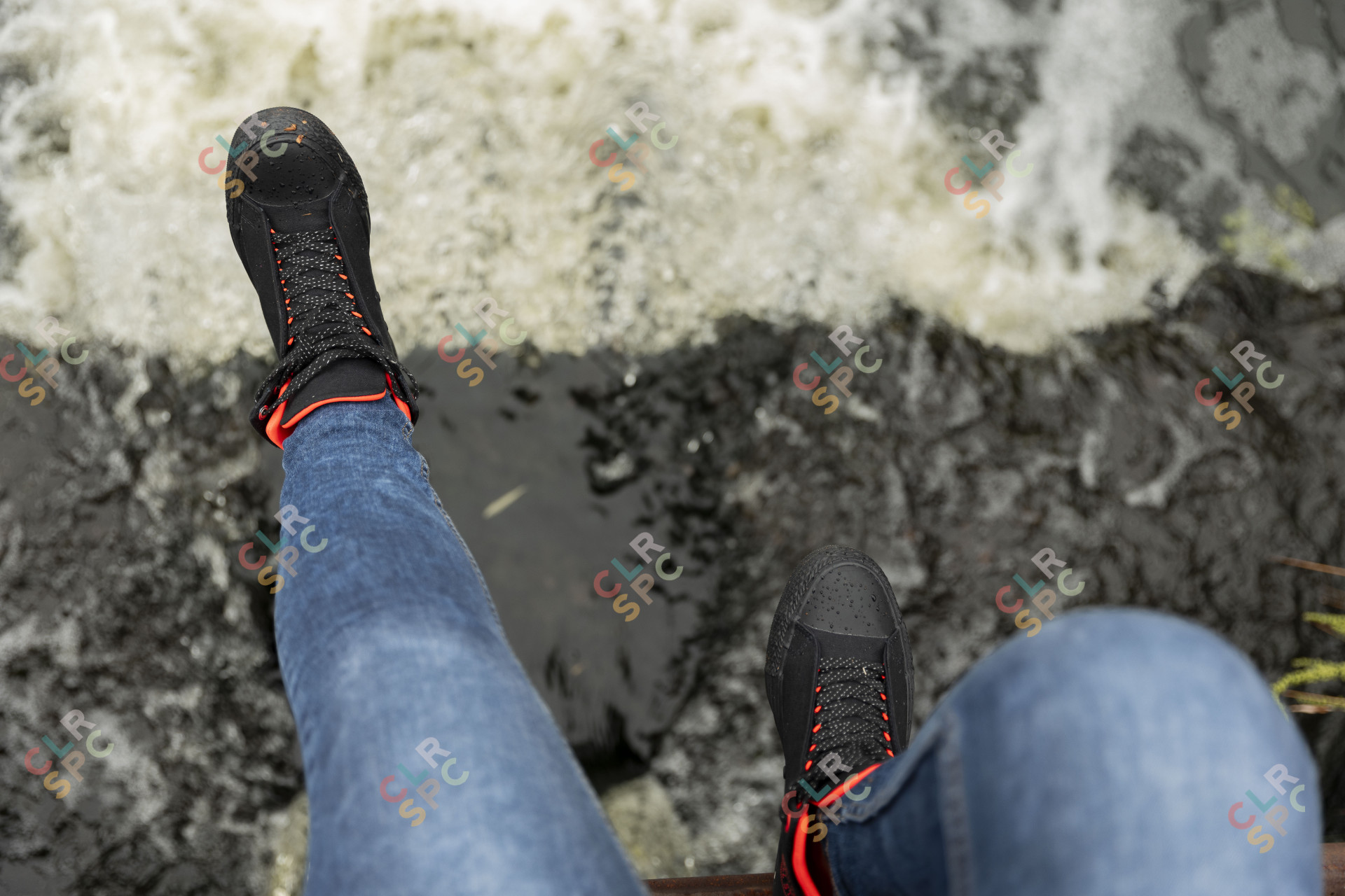 Black woman dangling feet by a river