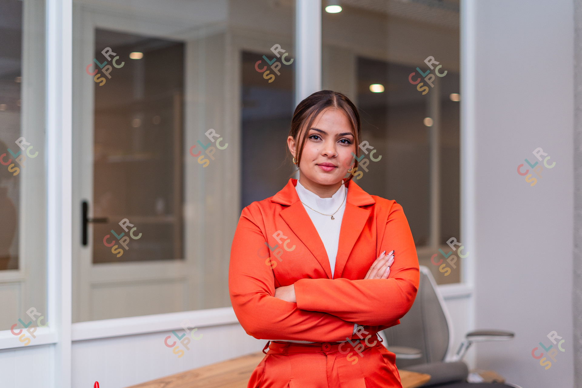 Professional South African woman wearing orange suit at the office.