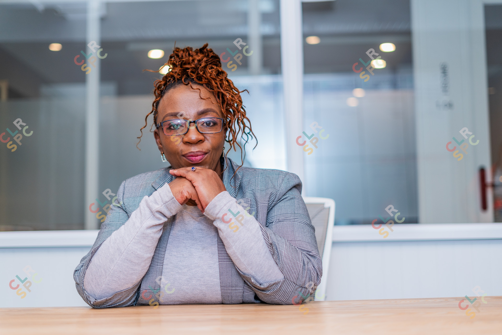 Mature black business woman looking at camera at work wearing glasses in a suit.