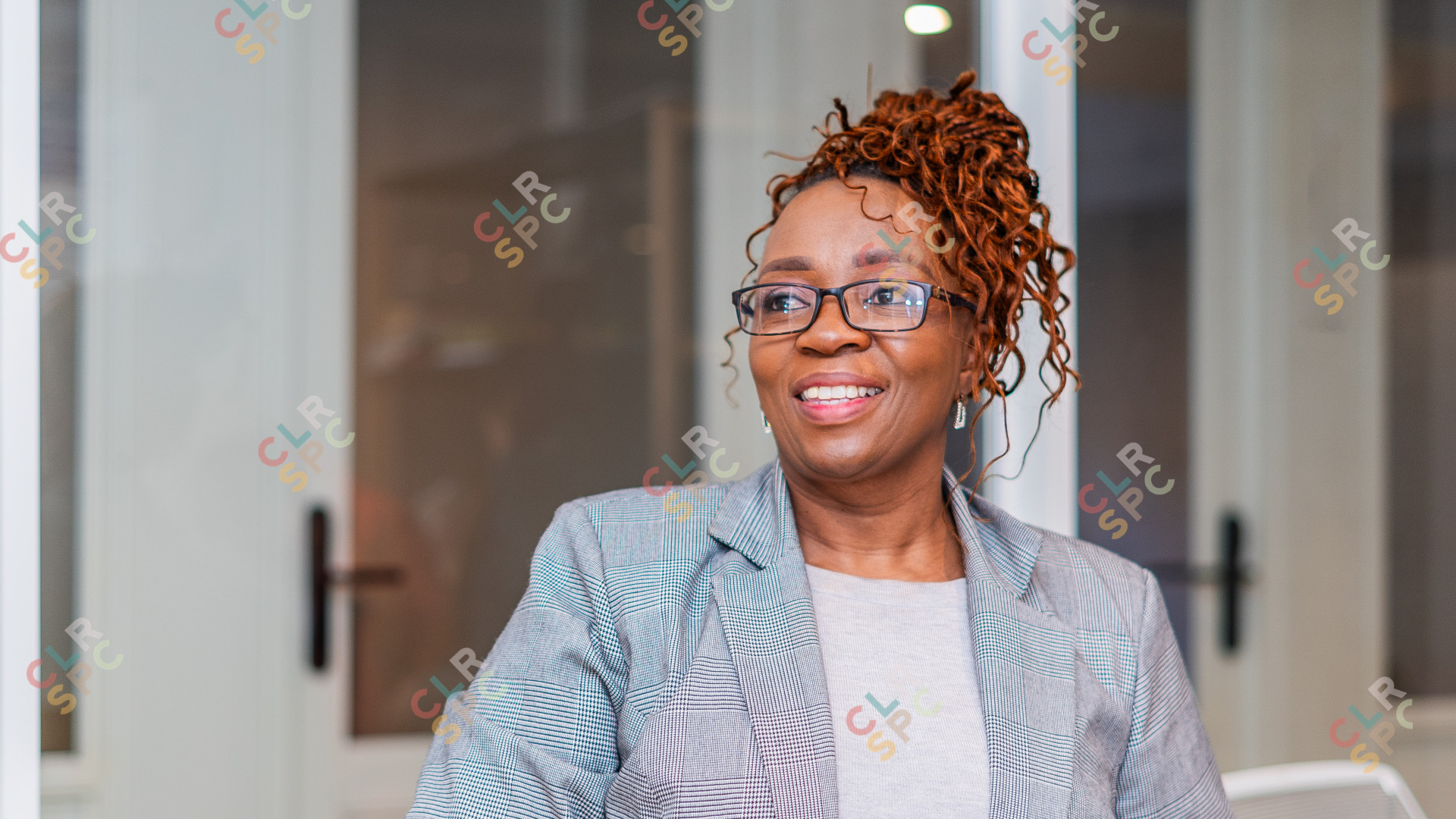 Black woman smiling wearing glasses at the office, CEO.