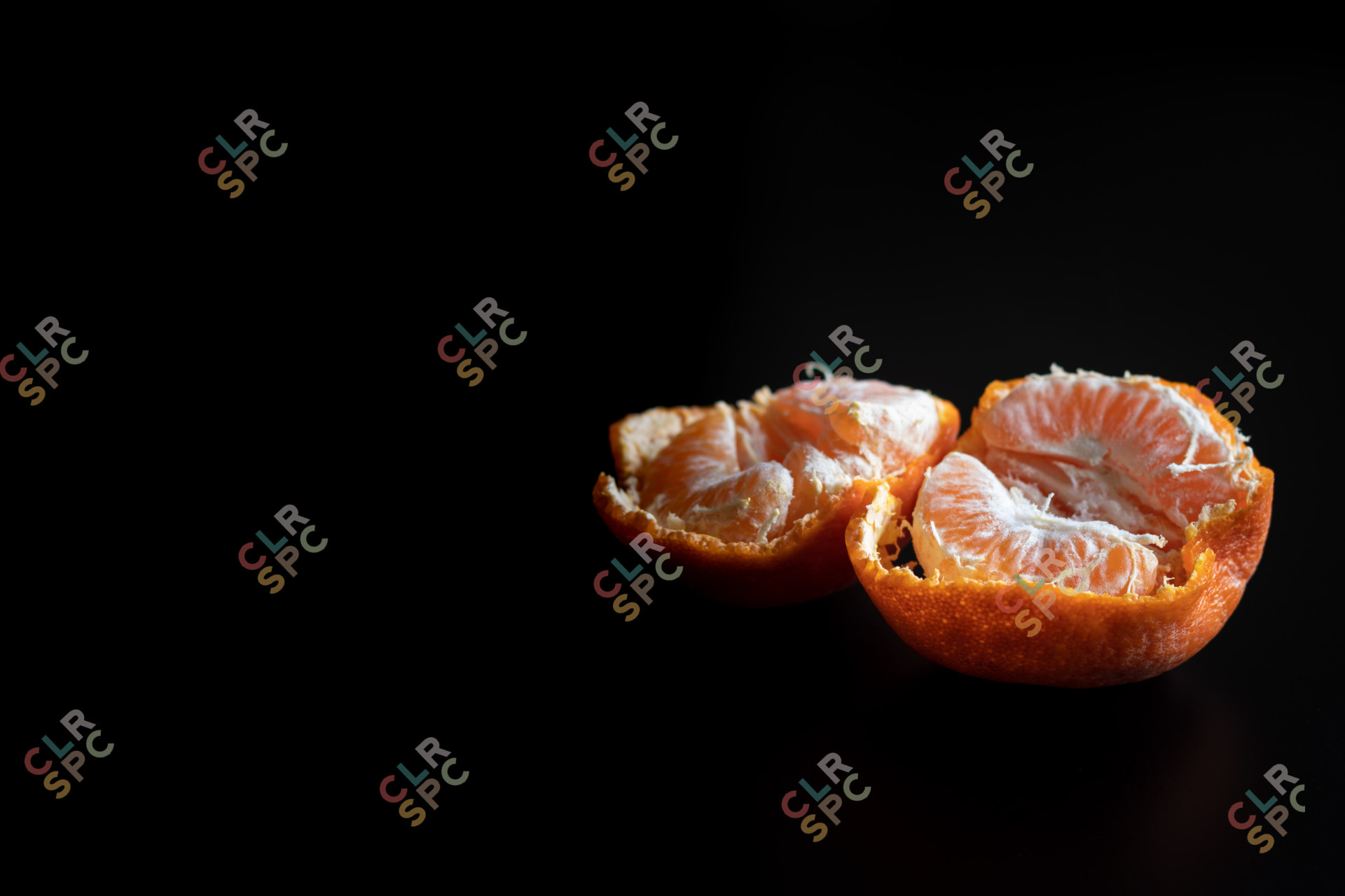 Fresh pealed mandarin / clementine on a black table